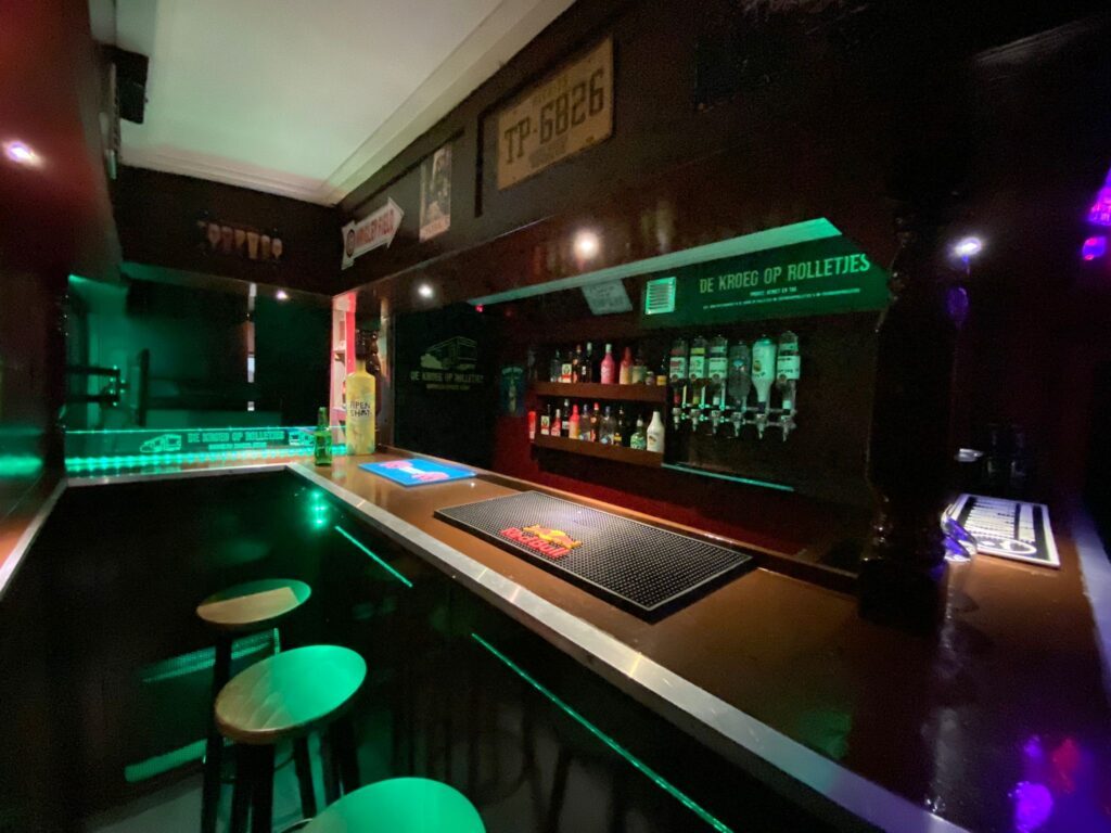 De bar met tapkranen en groene LED-verlichting.