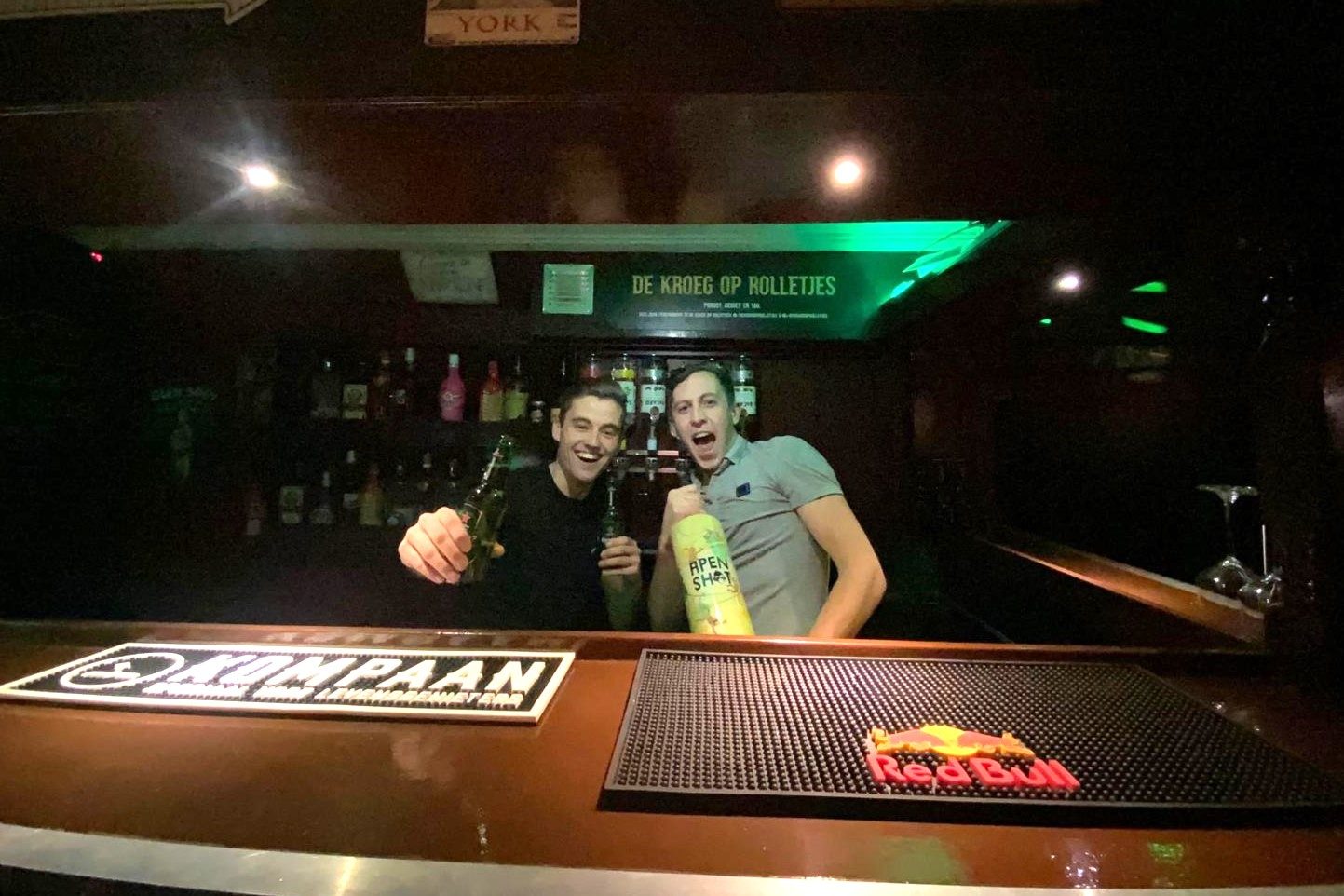 Bart en Perry achter de bar in de bus, met een biertje in de hand.