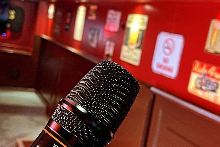 Karaokemicrofoon op de bar met de rode wand van de kroeg erachter.
